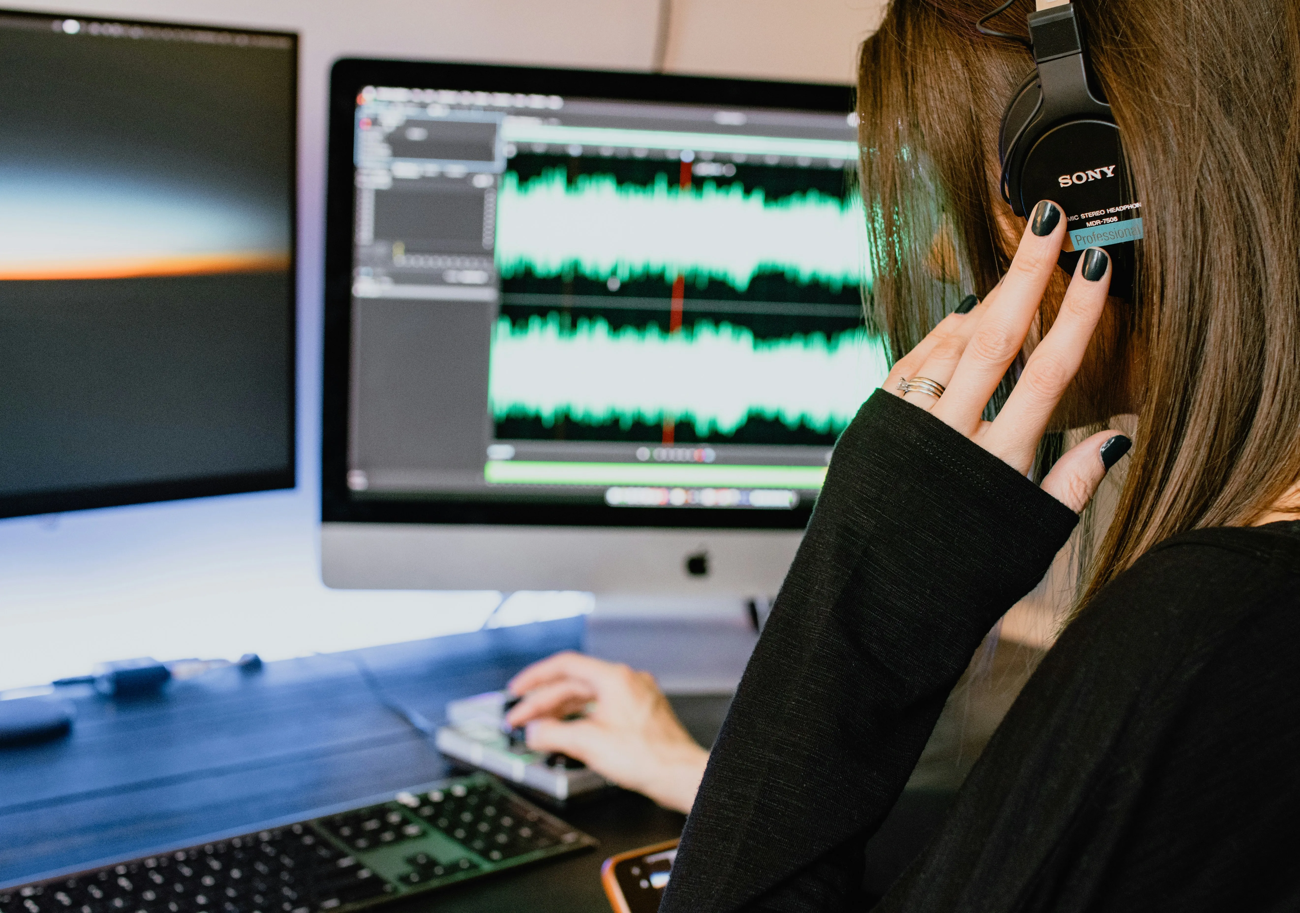Woman in black long sleeve shirt using a digital audio workstation